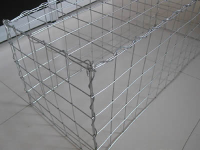 A welded gabion on the ground and connected by the lacing wire.
