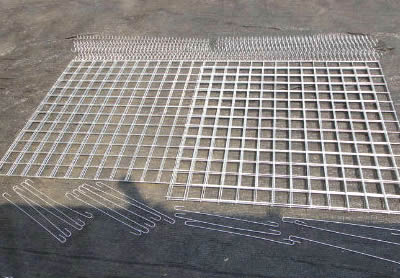 Welded gabion panels, spiral wires and stiffeners are on the ground.