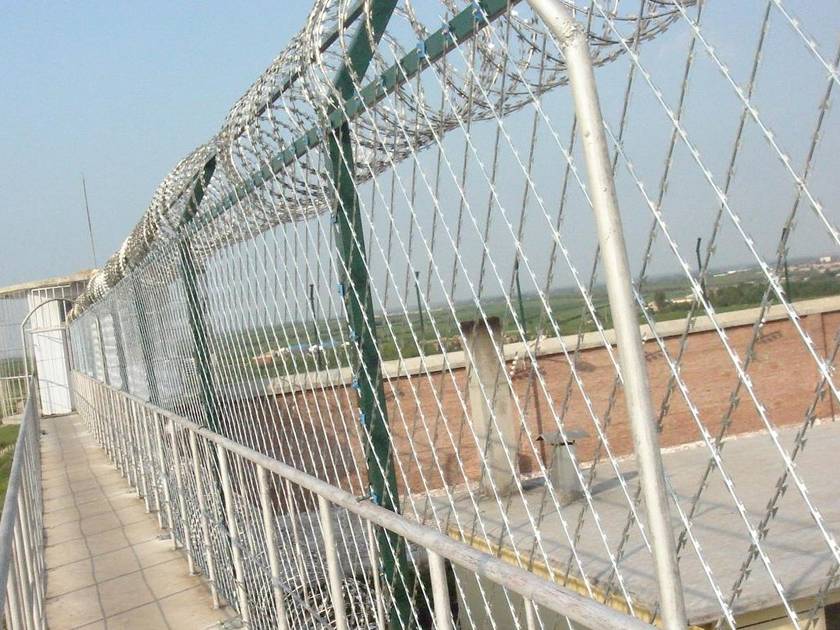 The galvanized welded razor fences are installed at the top of prison wall.