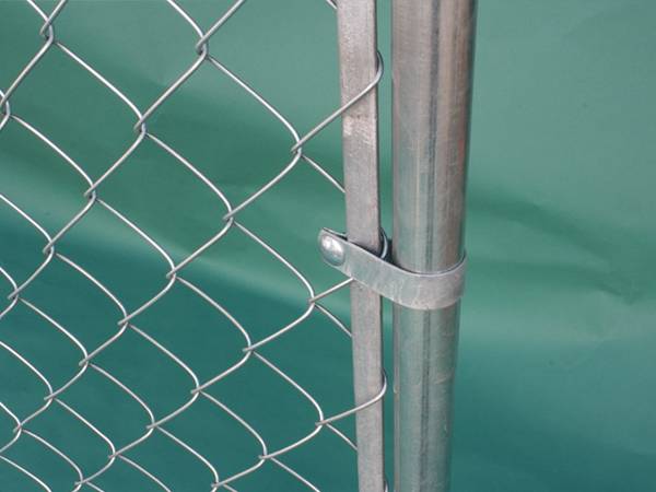 A close up picture of temporary chain link fence with flat tension bar.