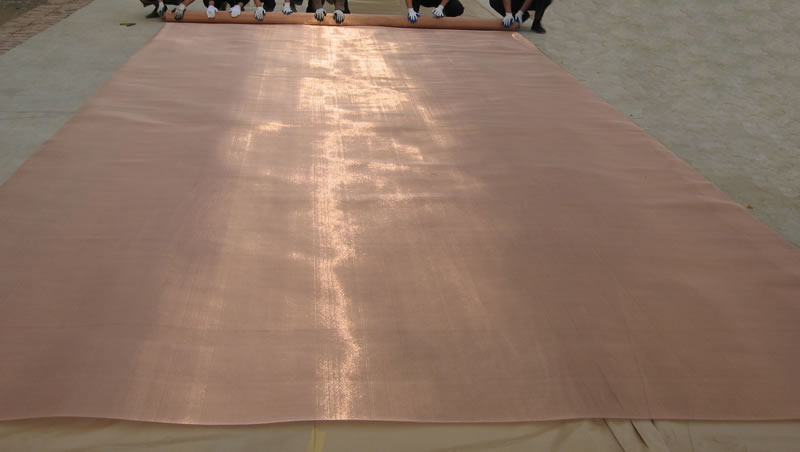 Superfine cable metal mesh in copper color is paving on land, and it is so slight that looks like cloth.