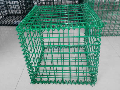 A green color PVC coating welded gabion on the ground.