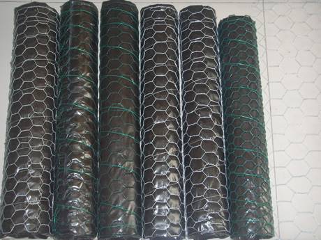 Six rolls of PVC coated chicken wire mesh packaged with black plastic film and chicken wire, three white and three green.