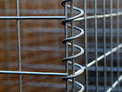 Neighbor welded gabion panels are connected with spiral wire.