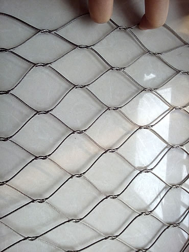 A piece of knotted rope mesh with diamond holes.