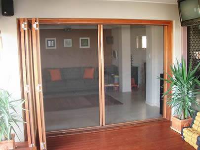 Two sliding doors in a house are made of galvanized insect screen.
