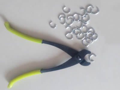 A pliers and several C rings on the gray background.