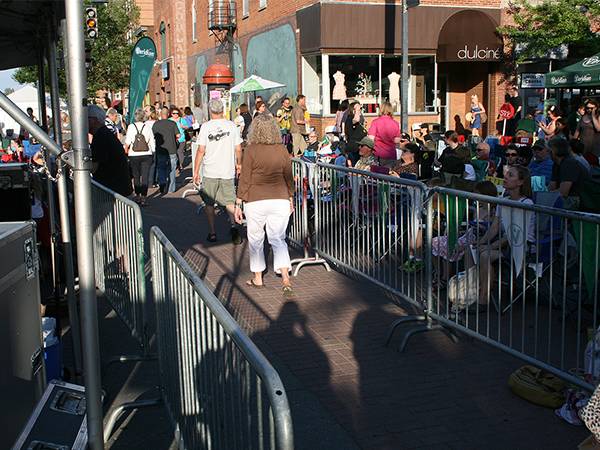 Crowd control barriers are separating a passage way on crowd street.