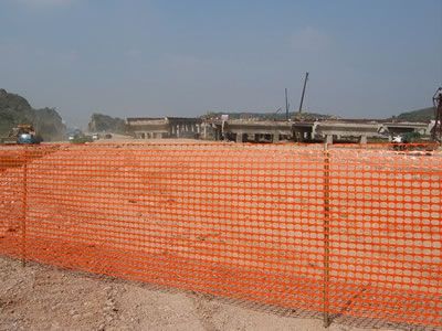 Orange construction fence is set in the demolition site.